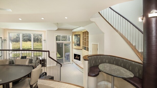 A modern interior with a dining area, a built-in bench, and a staircase.