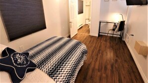 Une chambre à coucher avec un lit, un bureau et un téléviseur.