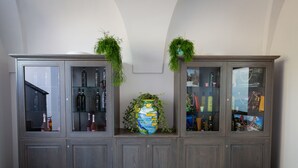 A large wooden cabinet with glass doors, containing various items and a large vase. - Relais Kaora (Sant'Agnello)