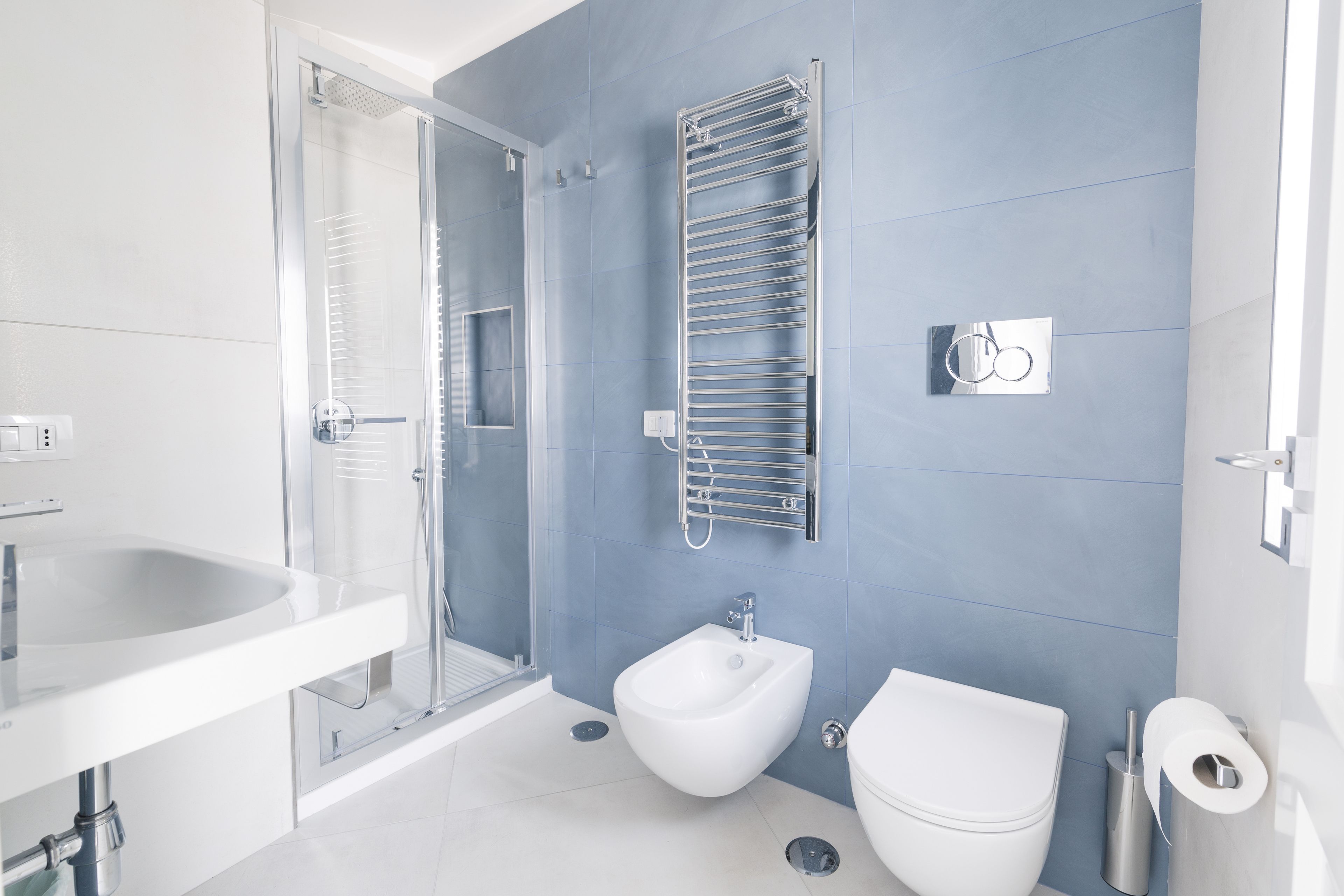 A modern bathroom with a shower, bidet, toilet, and a sink.