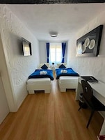 Una habitación con dos camas, un escritorio y una silla.