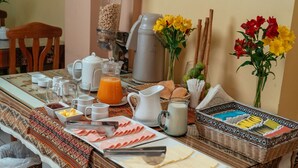 Un bufé de desayuno con diversos alimentos, bebidas y una máquina de café.
