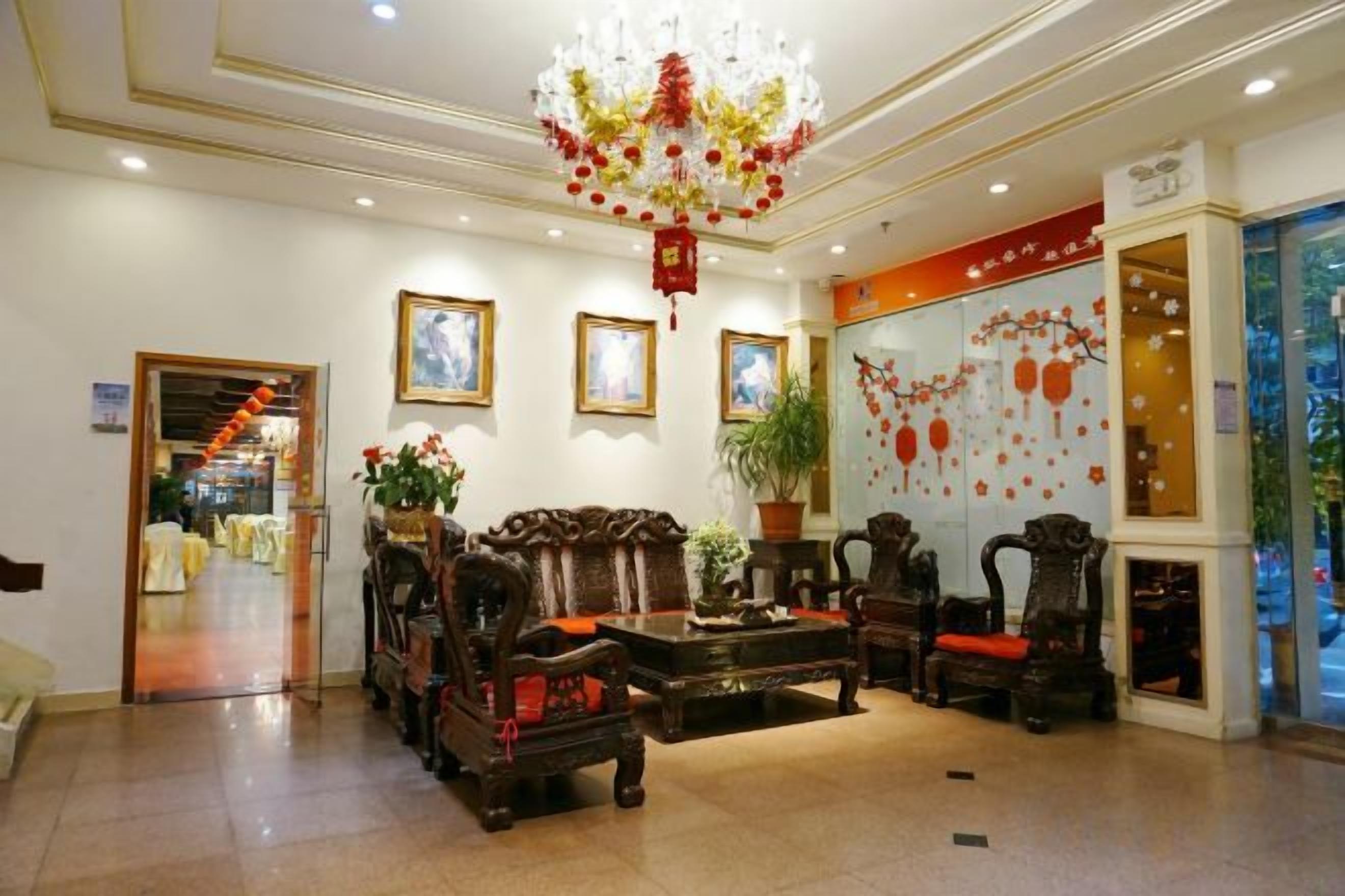 Eine Lobby mit traditionellen Möbeln, einer Chandelüster und gerahmten Kunstwerken an den Wänden.