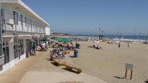 Een hotel aan het strand met terras en uitzicht op zee.