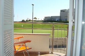 Enjoy the view of the sports field from this balcony with a seating area.