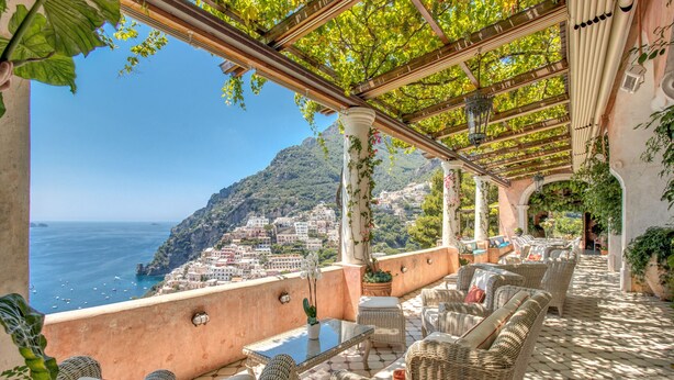 A terrace with wicker furniture, a glass table, and potted plants. - AMORE RENTALS - Villa San Giacomo – Historic Luxury Villa with Sea View (Positano)