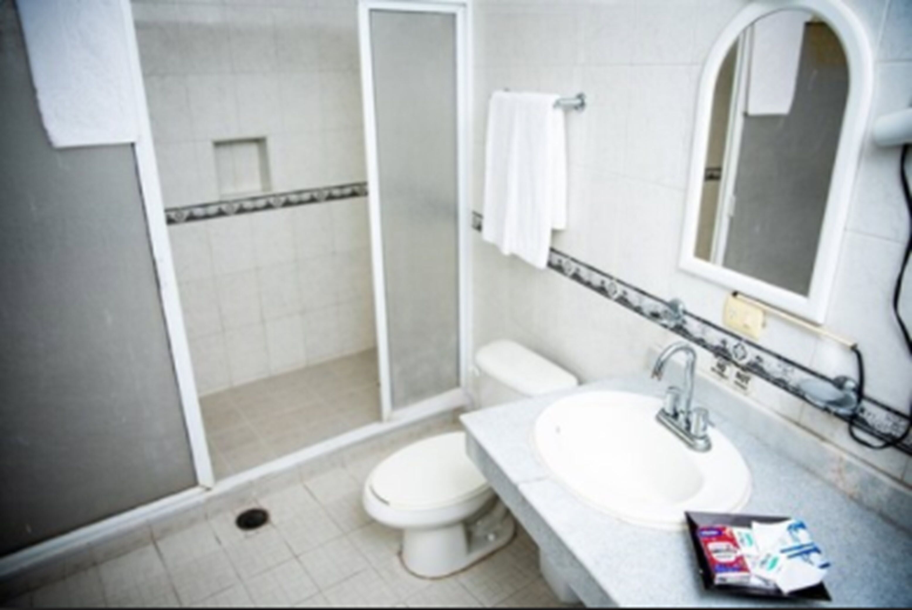 Un baño con inodoro, lavamanos y ducha.