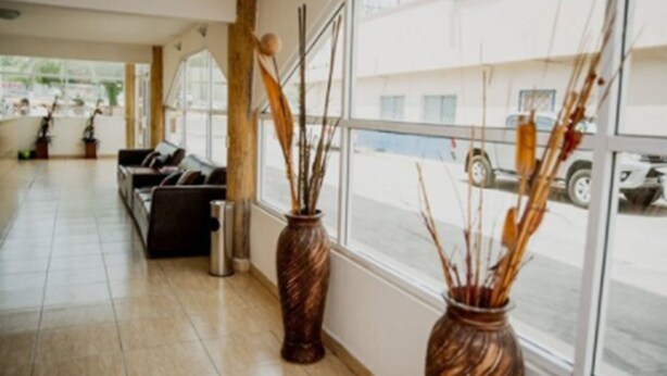 A spacious lobby with a sofa and two decorative vases. - Hotel Go Inn (Monclova)