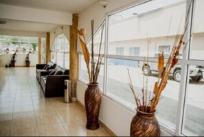A spacious lobby with a sofa and two decorative vases. - Hotel Go Inn (Monclova)