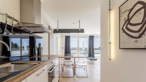 A modern kitchen with a large island, stainless steel appliances, and a view to the outside. - Apartment Villa Mila (Kaštel Novi)