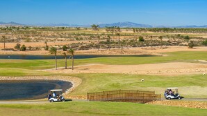 Ein Golfplatz mit Wasserhindernis, Sandfalle und Holzbrücke.