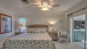 A bedroom with a bed, a ceiling fan, a nightstand, a chair, and a dresser.
