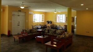 A spacious living area with a sofa set, a coffee table, and a dining table.