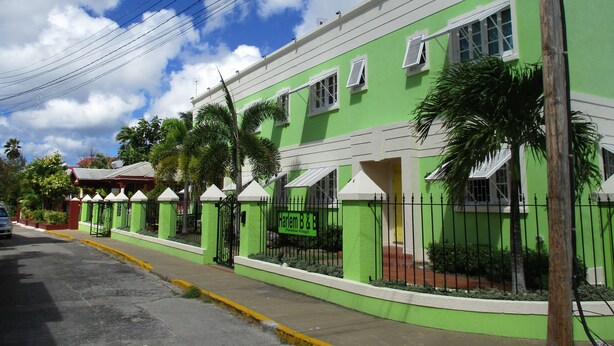 A green building with a sign reading "Harlem BZB Paradise Village."