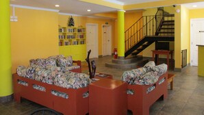 A lobby with a staircase, a bookshelf, and a small Christmas tree.