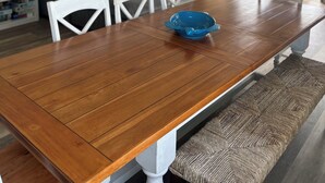 A dining area with a wooden table, white chairs, a ceiling fan, and a surfboard mural on the wall. - FALL SPECIAL PRICING Beautifully Remodeled Surf City Oceanfront on the beach (Surf City)