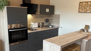 Eine moderne Küche mit Backofen, Toaster, Kaffeemaschine und Spüle.