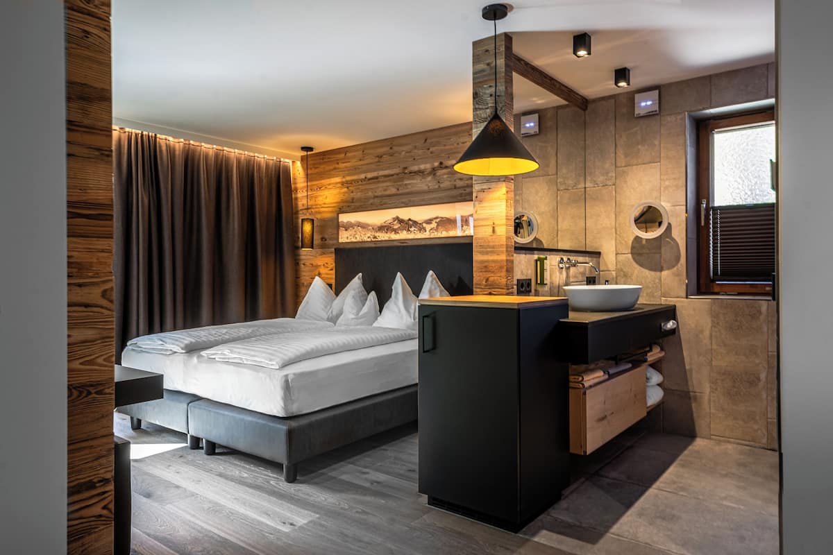 A modern bedroom with a bed, bedside table, and a built-in sink.