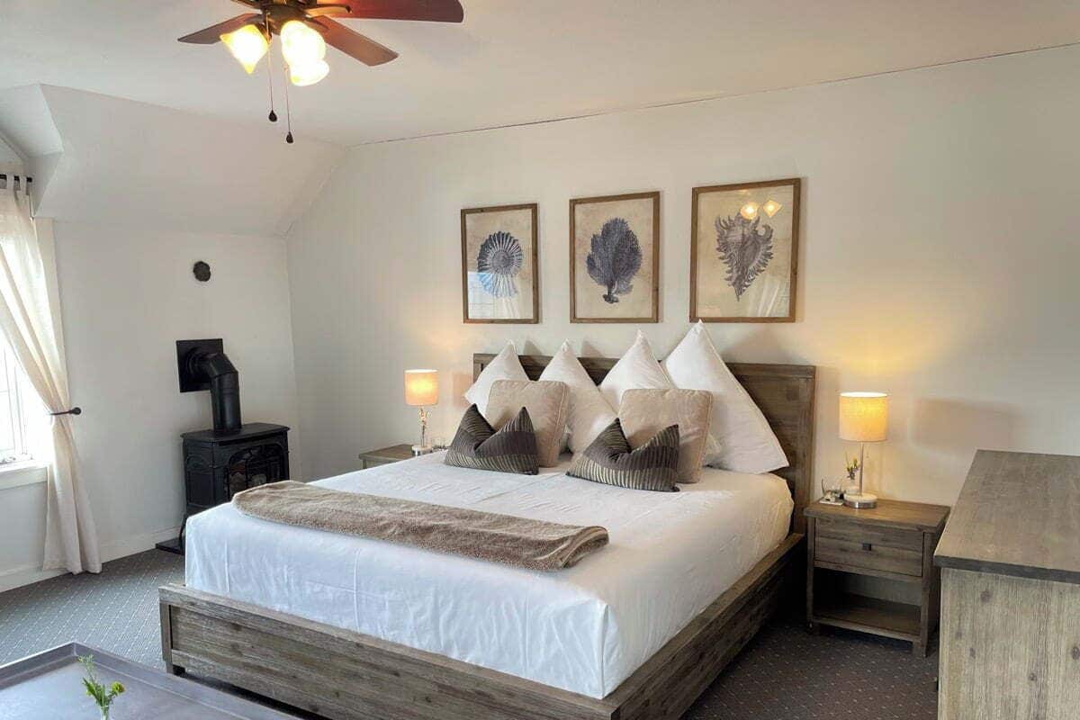 Un dormitorio con una cama de madera, una mesita de noche, una lámpara y un ventilador de techo.