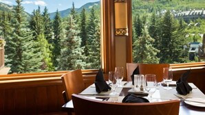 A dining table set for two with a view of a forest and mountains. - Beaver Creek Charter 2 Bed (Avon)