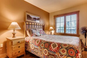 Comfortable bedroom with a large bed, nightstand, and window.