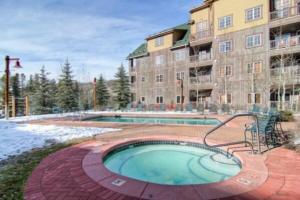 Guests can enjoy a hot tub and standard pool surrounded by a walkway.