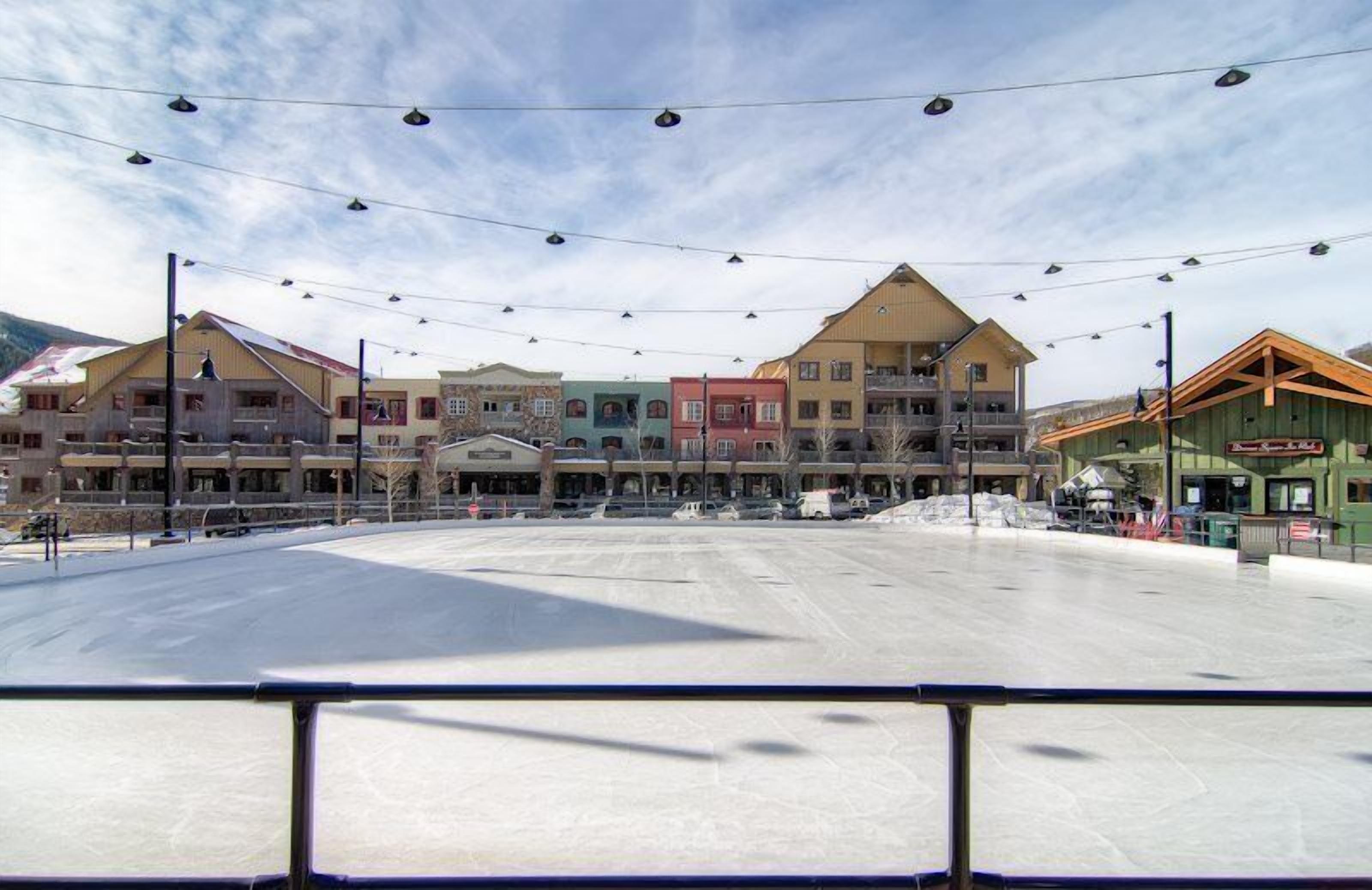 A hotel with multiple floors, balconies, and a ski lift visible in the background.
