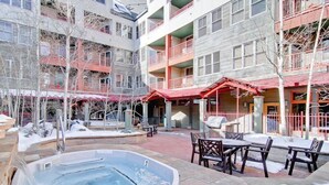 A multi-story building with outdoor seating and a hot tub.