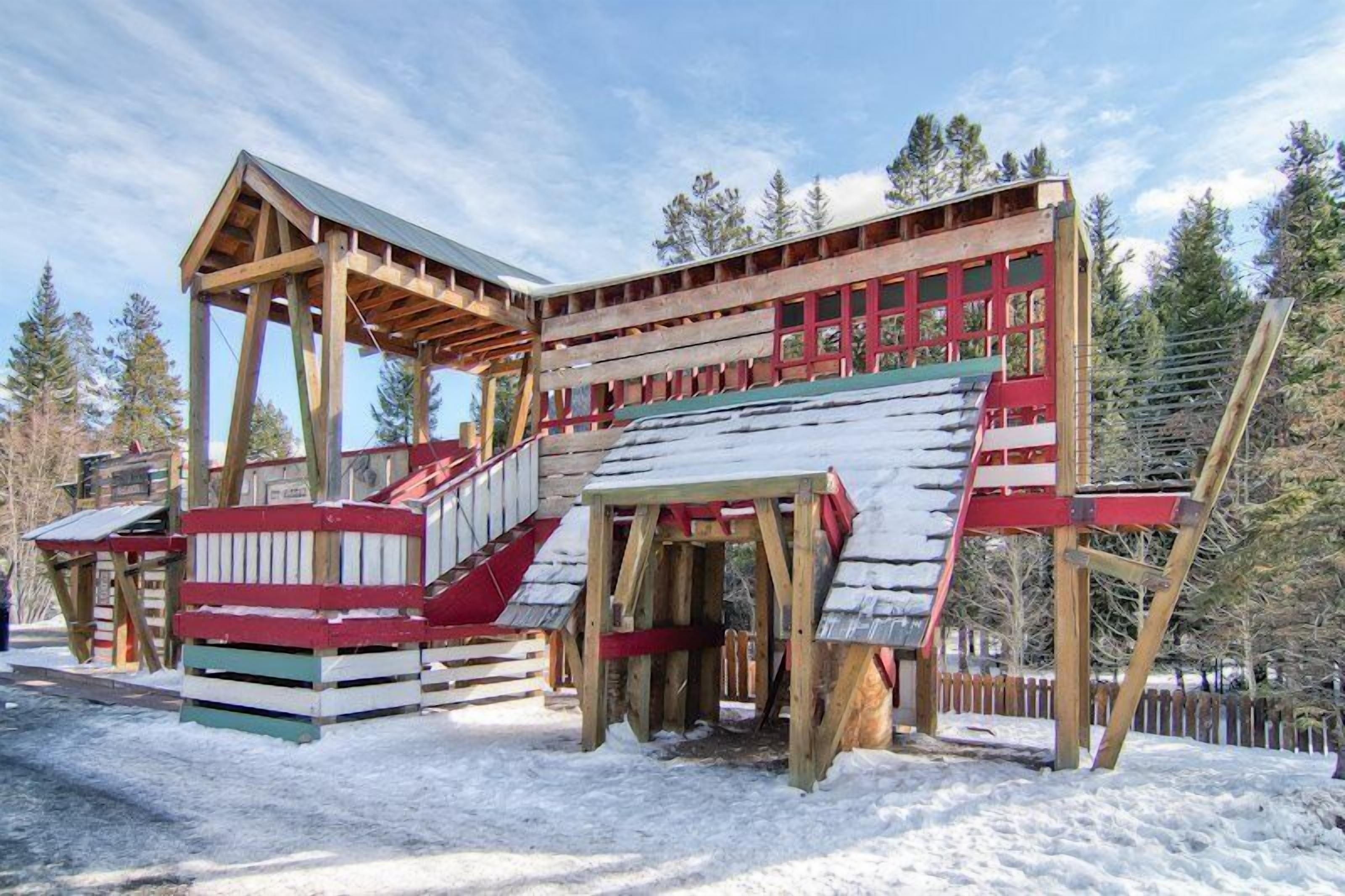 A wooden cabin with a steep staircase and a red and white exterior.