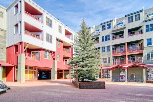 A multi-story building with balconies, a central courtyard, and a Christmas tree.