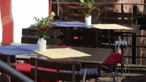 Zona salotto all'aperto con tavoli e sedie, alcune con piante in vaso.