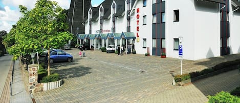 A hotel with a traditional design, featuring a central tower and multiple windows.