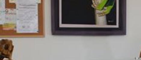 A framed painting of a frog on a wall.