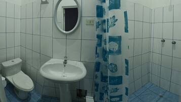 A bathroom with a toilet, sink, and shower.