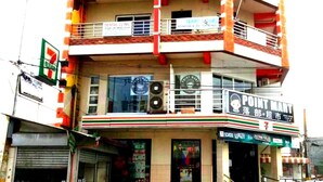 Un edificio de varios pisos con una tienda de conveniencia 7-Eleven en la planta baja, una clínica dental en el segundo piso y un Point Mart en el tercero.