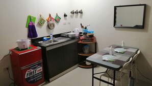 Cocina compacta con un lavamanos, estufa y mesa lista para comer.