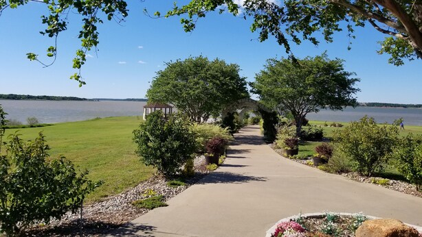 A pathway leading to a gazebo by a lake, surrounded by greenery and a clear sky. - Luxury Yurts on Lake Grapevine  (Southlake)