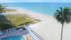 A beach with a pool and lounge chairs. - Beachcomber unit 504 (Longboat Key)