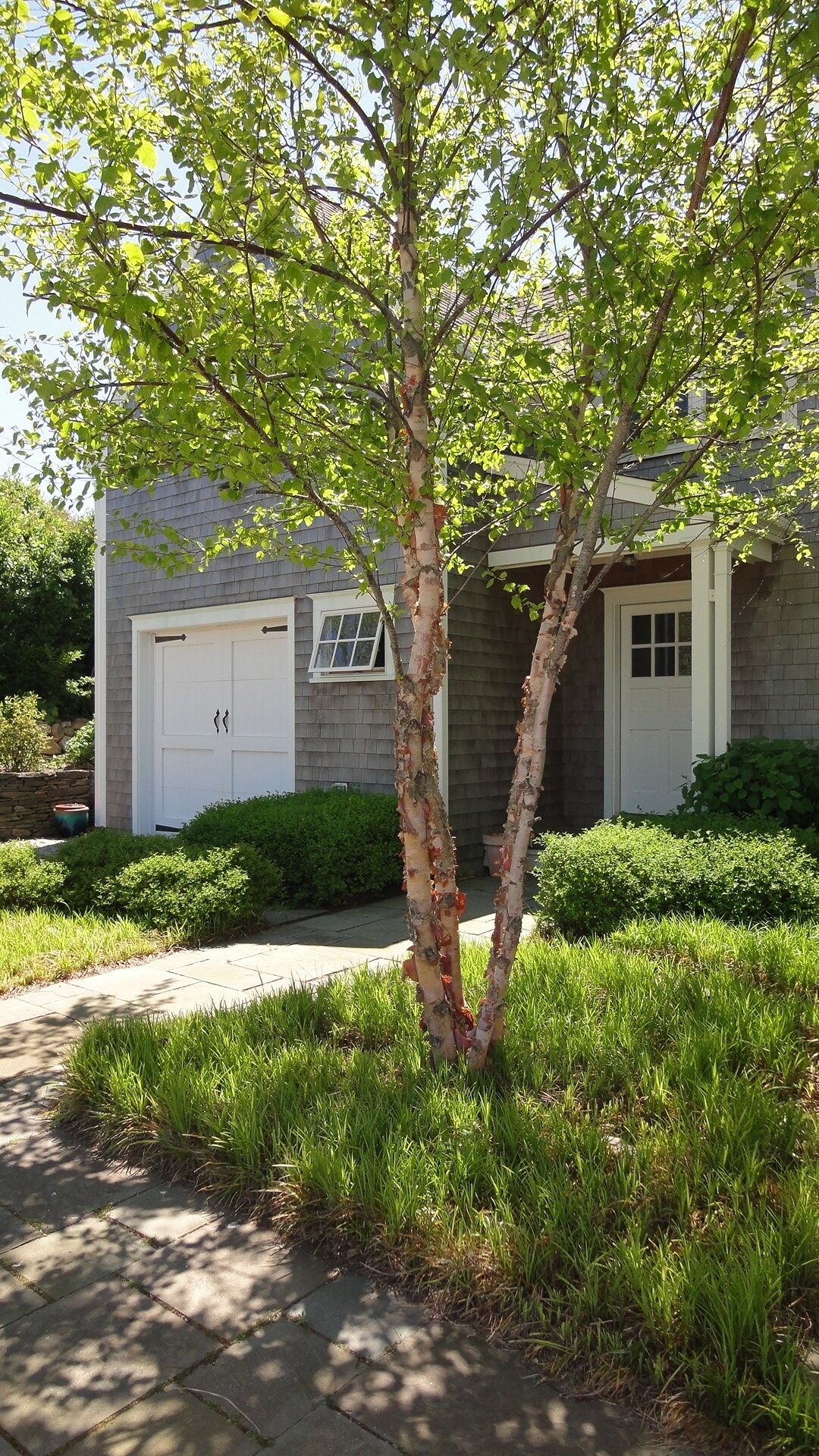 A two-story house with a garage, a front door, and a small window.