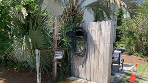 A wooden structure with a 'PRIVATE PROPERTY NO TRESPASSING' sign, a hose, and a wooden bench. - The Folly Jewel -  Sleeps 6 (Folly Beach)