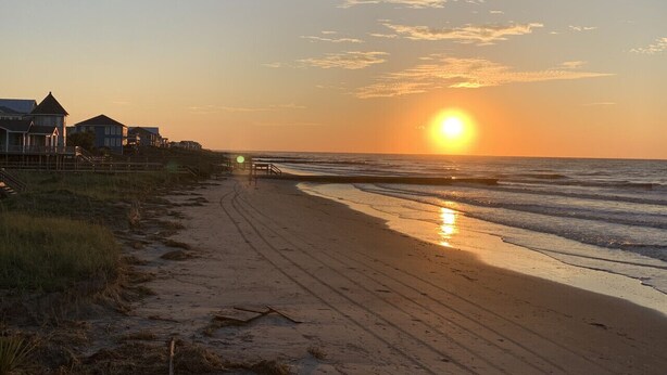 A beach with a sunset, a path leading to the water, and houses on the left. - The Folly Jewel -  Sleeps 6 (Folly Beach)