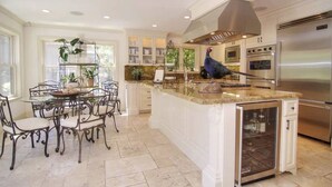 A spacious kitchen with a central island, built-in appliances, and a dining area with a metal table and chairs. - Splashpad. Steps from downtown and dining, shops and Starbucks. Walkable (San Jose)