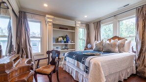 A bedroom with a large bed, wooden furniture, and a window with curtains. - Splashpad. Steps from downtown and dining, shops and Starbucks. Walkable (San Jose)