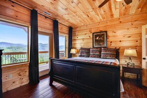 Cozy retreat with a large bed, windows, and a mountain view.