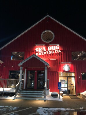 Een rood gebouw met een bord waarop staat: SEA DOG BREWING CO.