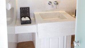 A bathroom with a white sink, a mirror, and a door.