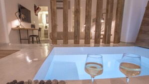 A room with a large table, two glasses of wine, and a pile of rocks.