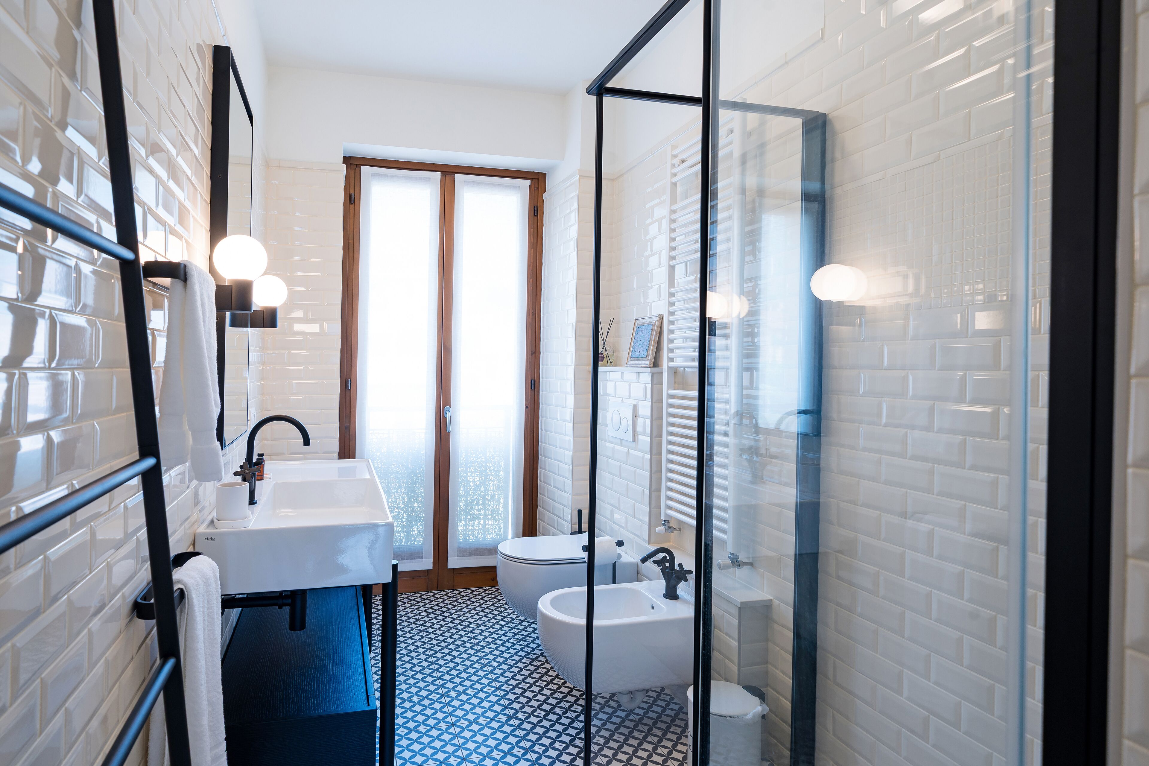 Een moderne badkamer met een witte wastafel, een badkuip en een douchecabine met glazen wanden.