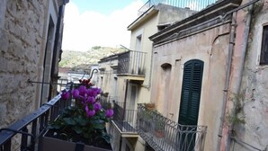 A narrow street with buildings featuring balconies and traditional architecture.