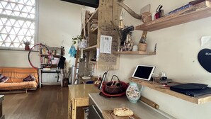 A cozy kitchen with wooden shelves, a dining table, and a sofa.